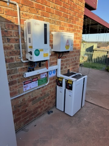 GRIDHUB residential battery installation on a brick home